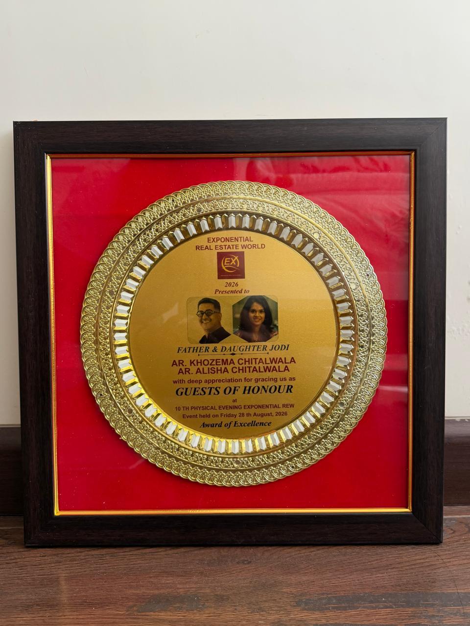 Exponential Real Estate World 2026 Award of Excellence plaque presented to Guests of Honour Khozema and Alisha Chitalwala